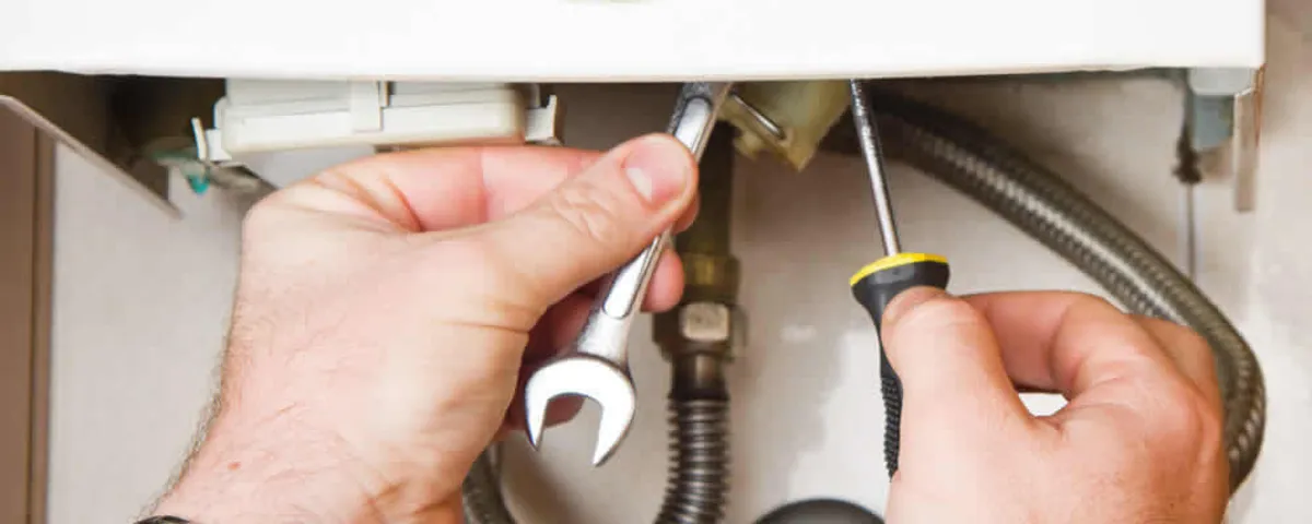 Boiler repair technician tightening pipe fittings and connections in Cherry Hill, NJ