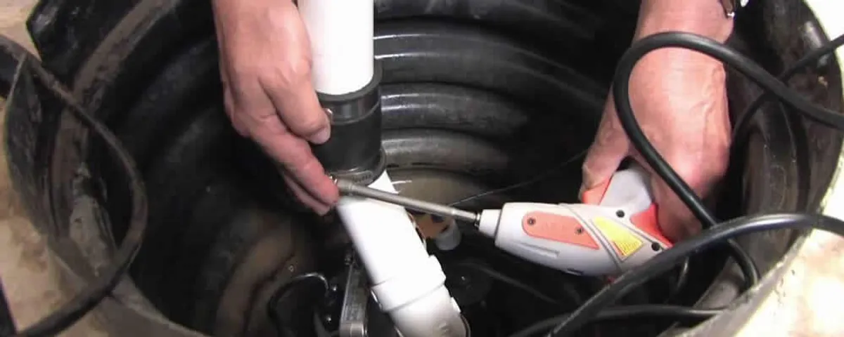 Sump pump installation technician connecting PVC discharge piping in Cherry Hill, NJ