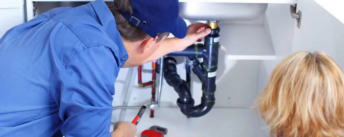 Plumber repairing under-sink drain pipes and fittings in Cherry Hill, NJ